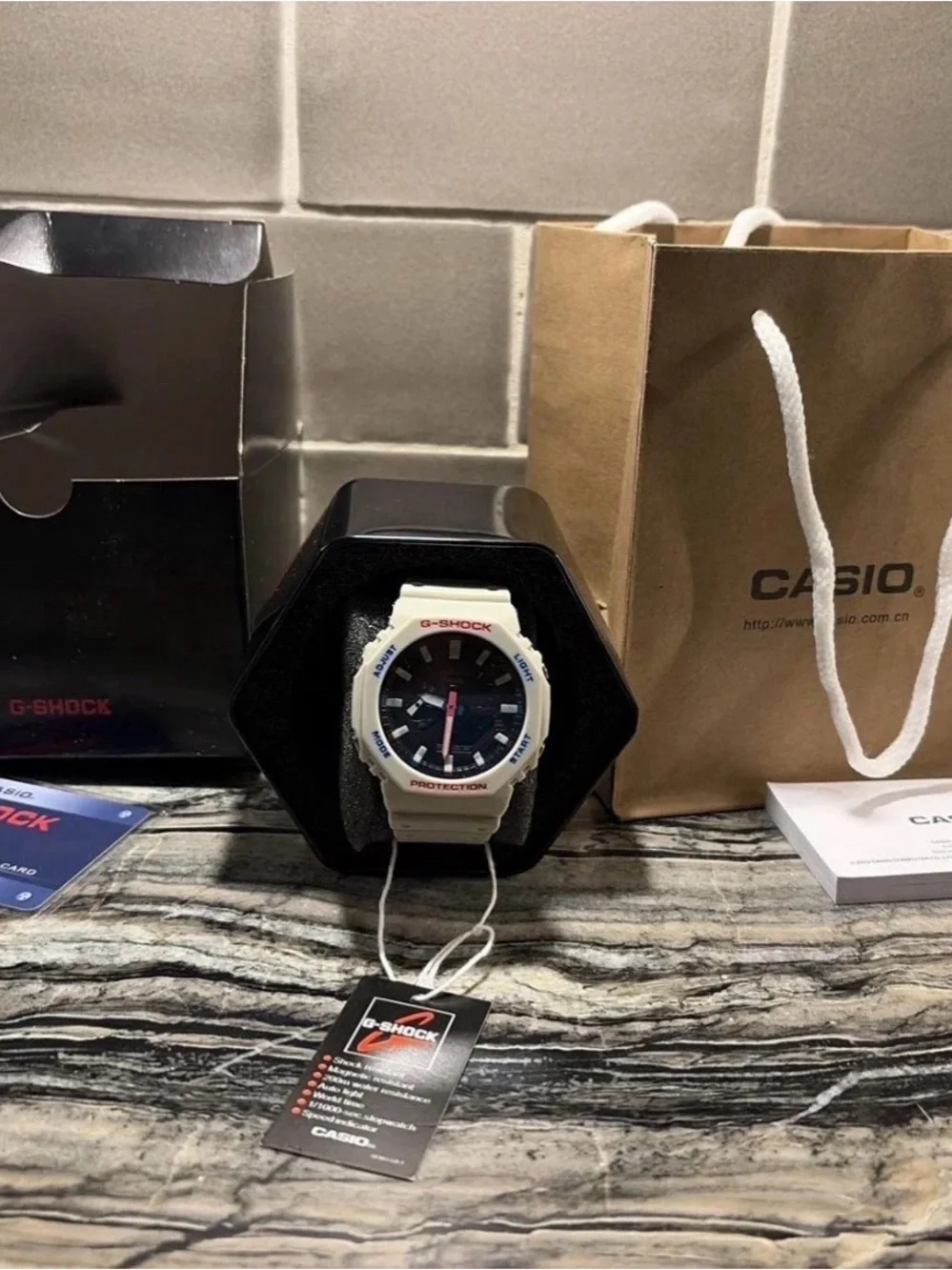 G-Shock White Bezel Black Dial Watch with Red and Blue Accents text 5045474637
